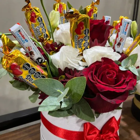 Caja pote con flores de estacion rosas y chocolates 